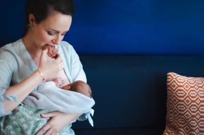 Jeune maman qui allaite en mangeant un snack maison