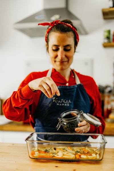 Cheffe Curcumamas en tablier qui ajoute des épices