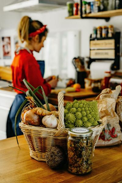 Cheffe en cuisine avec un panier de légumes