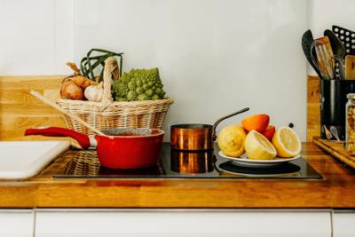 Cuisine avec panier de légumes, cocotte et agrumes