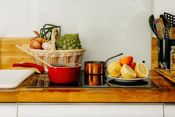 Cuisine avec panier de légumes, cocotte et agrumes